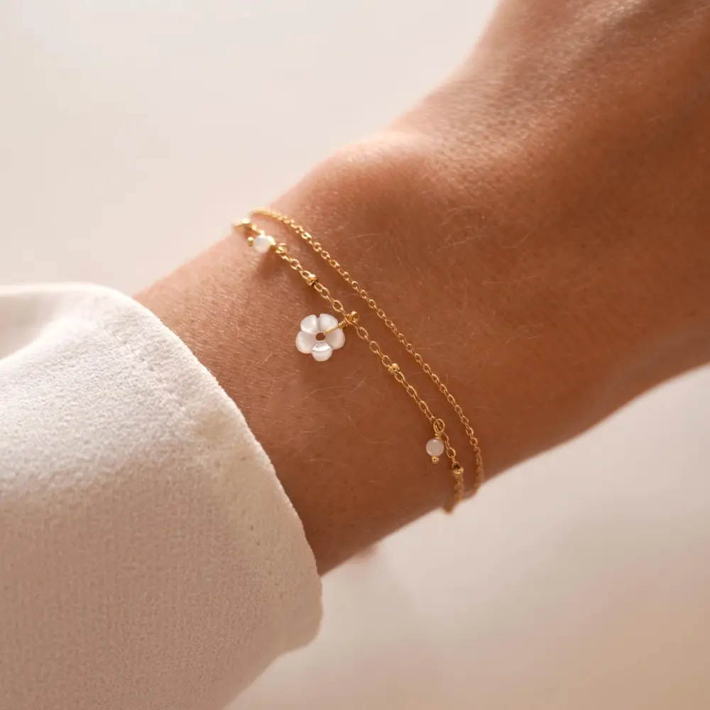 Frauegschichte - Meora Paris Doppelarmband mit weisser Blume und Perlen aus Perlmutt